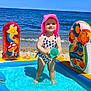 Mia is registered to the contest to win money with this photo: child, toddler, swimsuit, pink_hat, inflatable_pool, beach, ocean, water, sand, bucket, smile, standing, sunny, summer, waves, horizon, toy, play, family_vacation, happy