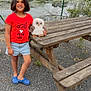 Saphyra a rejoint le concours — aidez-le/la à gagner de superbes lots ! child, outdoor, picnic_table, plush_toy, owl_plush, red_tshirt, denim_shorts, blue_crocs, smiling, gravel_ground, fence, water, trees, grass, nature, person, short_hair, casual_clothing, daylight, playful