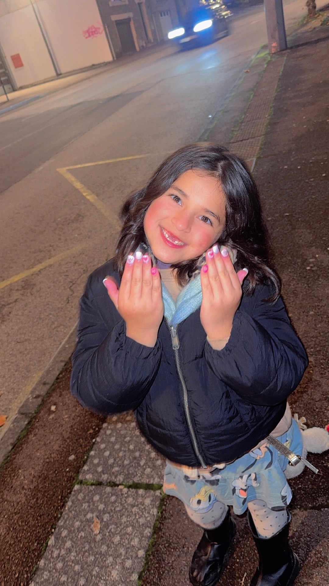 Saphyra participe au concours pour gagner de l'argent avec cette photo : child, girl, smiling, night, sidewalk, jacket, nail_art, skirt, cartoon_characters, boots, street, urban, happy, posing, outdoor, pavement, dark_hair, long_hair, cheerful, winter_clothing