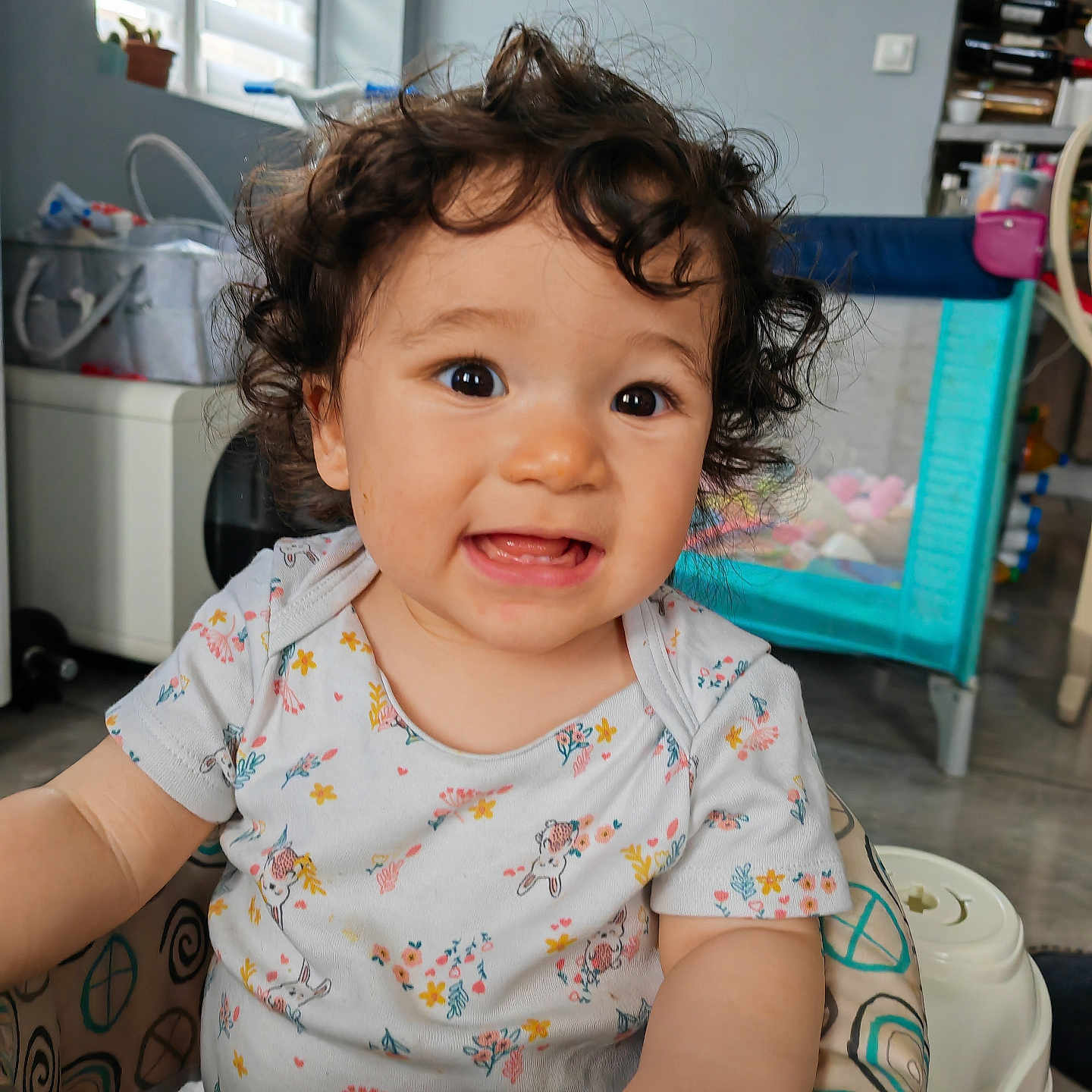 Kimmy a rejoint le concours — aidez-le/la à gagner de superbes lots ! baby, baby_clothing, bright_eyes, child, curly_hair, cute, expression, face, floor, furniture, happy, home, indoor, onesie, person, play_area, smiling, toddler, toys, walker