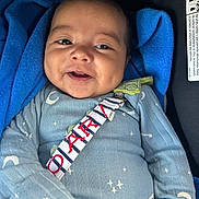 Liam joined the competition — help win amazing prizes! baby, smiling, blue_blanket, blue_clothing, moon_pattern, star_pattern, infant, closeup, portrait, happy, child, seatbelt, car_seat, soft_texture, cozy, cute, young_child, face, safety_strap, indoor