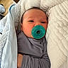 Charlie is registered to the contest to win money with this photo: baby, pacifier, blanket, pillow, sleepy, indoor, infant, cute, cozy, soft, child, resting, comfort, clothing, portrait, newborn, person, wrapped, face, hand