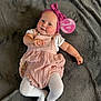 baby, infant, pink_headband, pink_romper, white_tights, blanket, soft_texture, milestone_sign, lying_down, cute, smiling, child, person, indoors, portrait, headwear, fabric, skin, cheeks, small