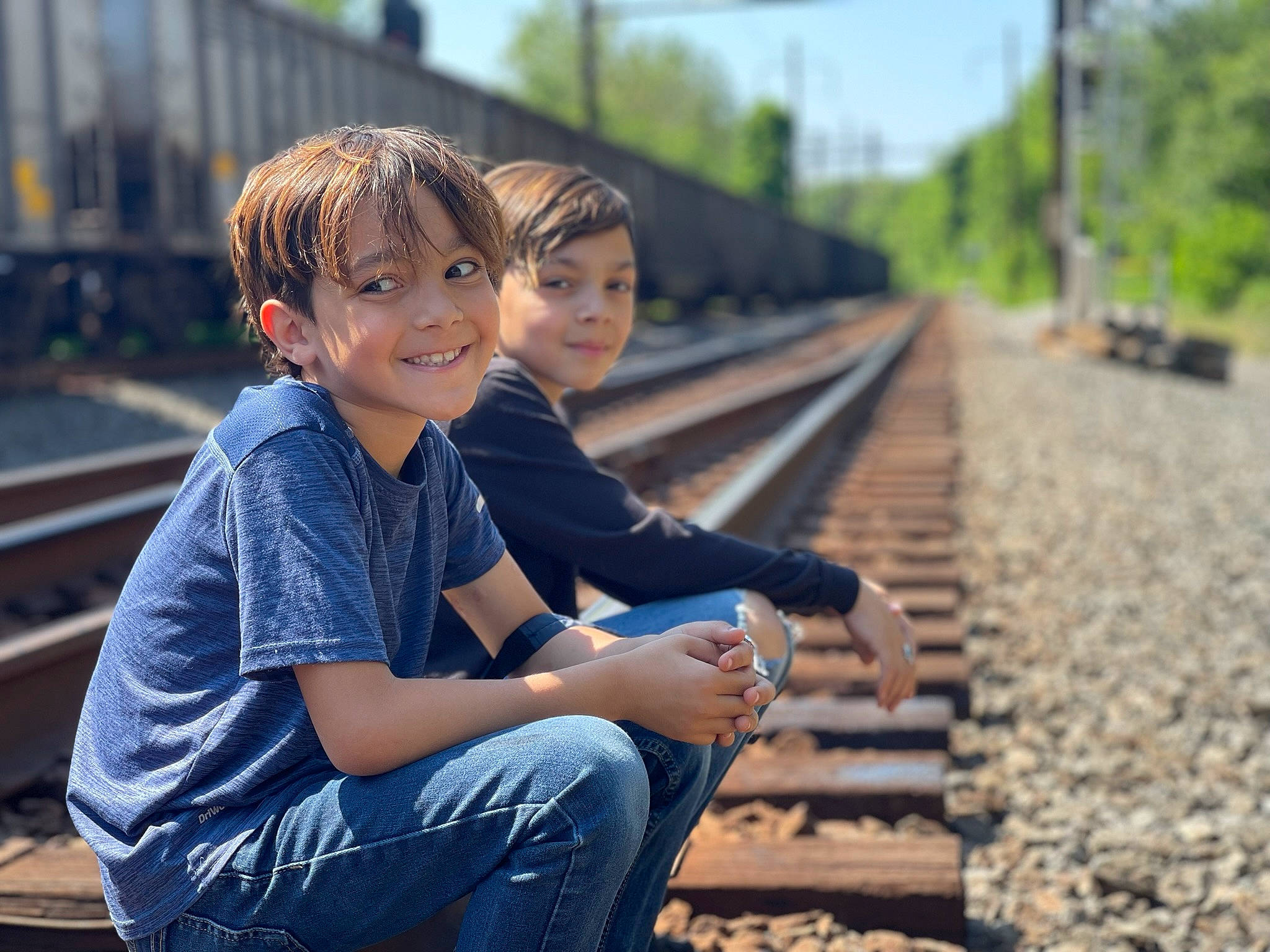 Destin is registered to the contest to win money with this photo: child, denim, flash_photography, fun, grass, happy, headwear, jeans, joy, leisure, people, people_in_nature, person, railway, recreation, rolling, sitting, smile, spring, track