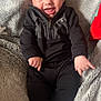 Cathaoir is registered to the contest to win money with this photo: baby, infant, smiling, black_clothing, blanket, soft_texture, happy, cute, child, socks, lying_down, face, portrait, cozy, indoor, small_hands, blue_eyes, casual_wear, expression, young_child
