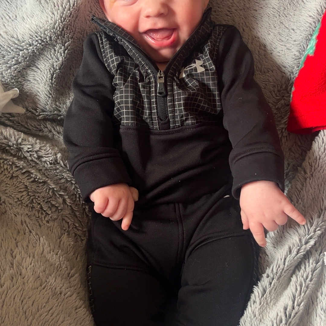 Cathaoir joined the competition — help win amazing prizes! baby, black_clothing, blanket, blue_eyes, casual_wear, child, cozy, cute, expression, face, happy, indoor, infant, lying_down, portrait, small_hands, smiling, socks, soft_texture, young_child