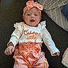 baby, child, infant, smiling, happy, portrait, indoors, couch, pillow, bow, headband, pink_outfit, pumpkin_pattern, seasonal, autumn, white_shirt, sitting, lying_down, baby_clothing, close_up