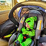 baby, infant, child, car_seat, car, vehicle, costume, green_costume, monster_costume, sleeping, face, portrait, indoor, travel, seatbelt, harness, neon_green, colorful, automotive, street_view