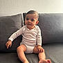 baby, barefoot, child, couch, curious, face, foot, furniture, hand, home, indoor, infant, long_sleeve, person, sitting, skin, sofa, texture, wall, white_clothing