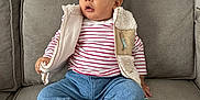 Sajed participe au concours pour gagner de l'argent avec cette photo : toddler, child, couch, indoor, clothing, vest, striped_shirt, jeans, red_socks, sitting, curious, face, person, furniture, home, casual, cozy, portrait, young_child, comfortable