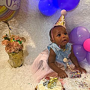 Danielle joined the competition — help win amazing prizes! baby, infant, child, birthday, cake, balloons, party_hat, confetti, dress, flowers, fuzzy_rug, celebration, portrait, sitting, decoration, pastel_colors, purple_balloons, gold_accents, surprised_expression, beaded_pacifier