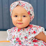 Victoire a rejoint le concours — aidez-le/la à gagner de superbes lots ! baby, child, closeup, colorful, cute, face, fashion, floral_dress, happy, headwrap, innocent, outdoor, pattern, person, portrait, pretty, sitting, smiling, toddler, young