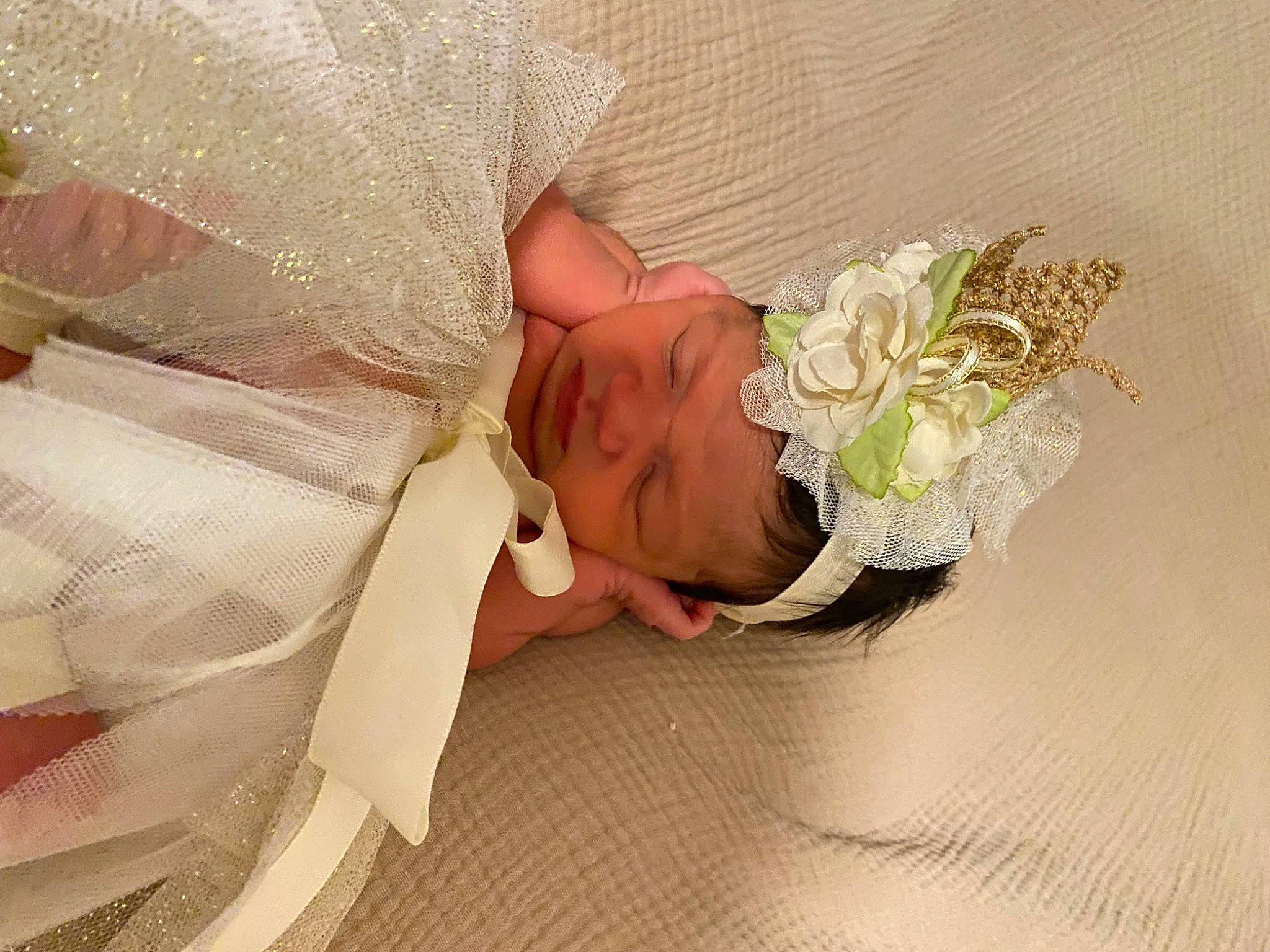 Gianna is registered to the contest to win money with this photo: baby, baby_toddler_clothing, bridal_accessory, comfort, cut_flowers, dress, embellishment, event, fashion_accessory, flower, flower_arranging, hair_accessory, happy, headband, headgear, headpiece, headwear, human_body, jewellery, person