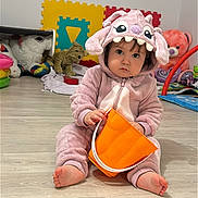 Lola a rejoint le concours — aidez-le/la à gagner de superbes lots ! baby, child, onesie, pink_clothing, orange_bucket, plush_toys, floor, foam_puzzle, indoor, serious_expression, sitting, toy, playroom, cute, person, headwear, foot, hand, face, hooded_clothing