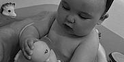 Lola participe au concours pour gagner de l'argent avec cette photo : baby, bathtub, water, toy, rubber_duck, floating_ring, child, bath_time, wet_hair, black_and_white, legs, skin, infant, cute, indoor, play, relaxation, parent, support, sitting