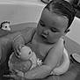 baby, bathtub, water, toy, rubber_duck, floating_ring, child, bath_time, wet_hair, black_and_white, legs, skin, infant, cute, indoor, play, relaxation, parent, support, sitting
