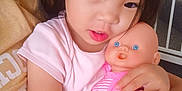Angela is registered to the contest to win money with this photo: toddler, child, baby_doll, pink_clothing, indoor, hugging, cute, person, face, hand, dark_hair, curious_eyes, soft_skin, casual_wear, toy, close_up, affection, caring, young_child, family