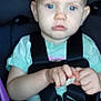child, toddler, baby, car_seat, seatbelt, harness, blue_eyes, short_hair, hands, snack, vehicle_interior, portrait, closeup, sitting, seat_buckle, pink_button, unfocused, soft_lighting, serious_expression, infant_clothing