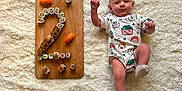 Camille participe au concours pour gagner de l'argent avec cette photo : baby, clothing, face, food, hardwood, head, hosiery, newborn, number, person, photography, portrait, sitting, sleeve, sock, stainedwood, symbol, text, toy, wood