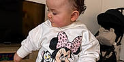 Jeanne a rejoint le concours — aidez-le/la à gagner de superbes lots ! baby, toddler, child, profile, sweatshirt, minnie_mouse, cartoon, bow, hair, table, indoor, stroller, television, lamp, sitting, leggings, white_clothing, cute, hand, wooden_table