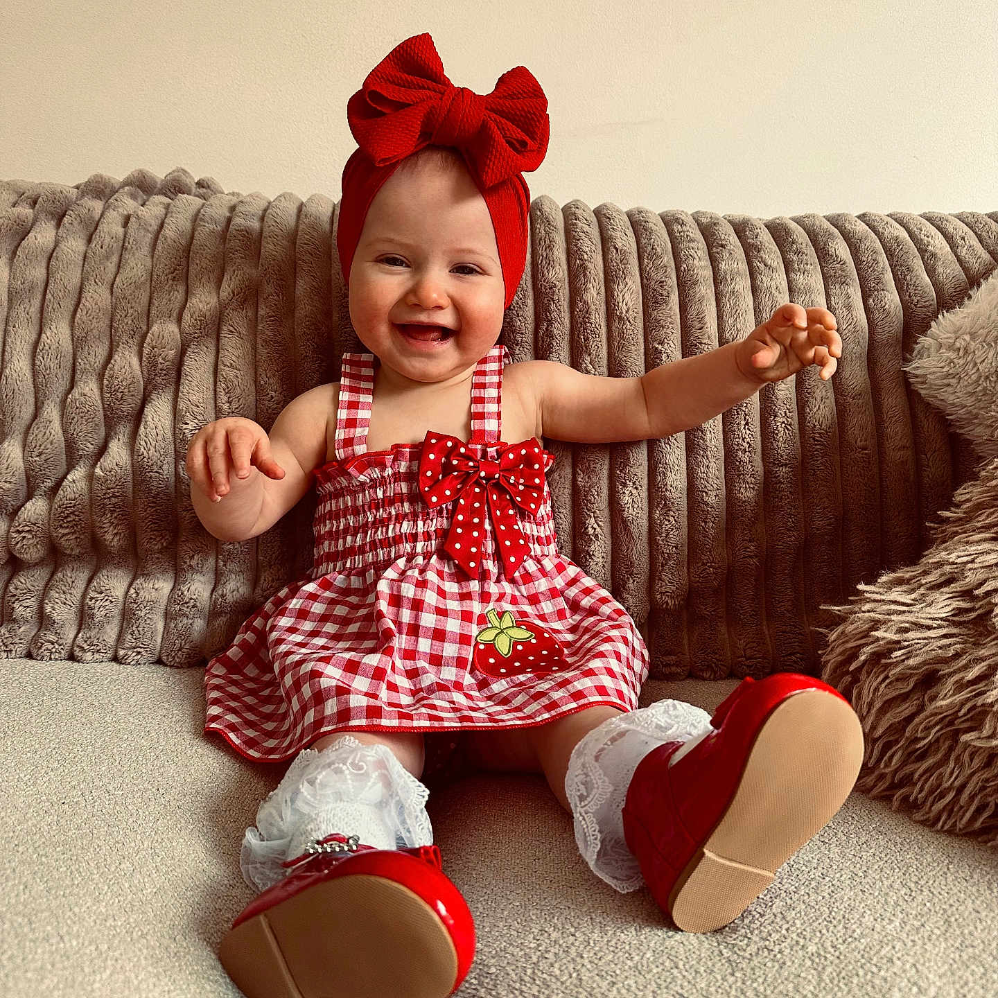 Minii is registered to the contest to win money with this photo: baby, beige_couch, checkered_dress, child, couch, cute, furniture, happy, headband, indoor, infant, pillows, portrait, red_bow, red_shoes, sitting, small_child, smiling, strawberry_patch, white_lace_socks