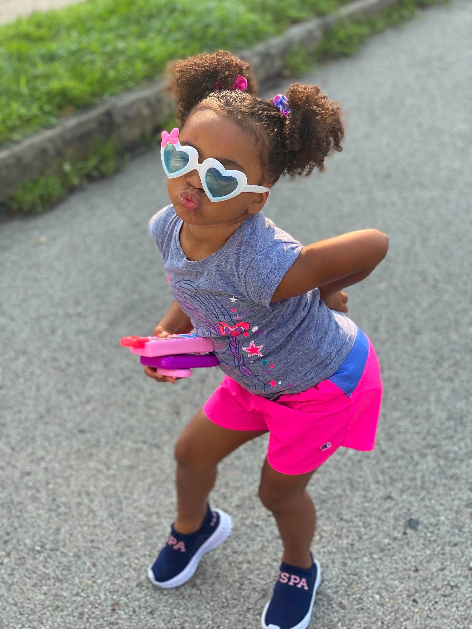Elaynah is registered to the contest to win money with this photo: asphalt, eyewear, glasses, goggles, grass, happy, leisure, magenta, person, pink, plant, recreation, shoe, shorts, sleeve, sneakers, street_fashion, sunglasses, t_shirt, thigh