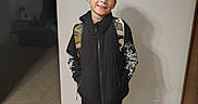 Bentley joined the competition — help win amazing prizes! child, boy, smiling, portrait, indoors, backpack, jacket, vest, pants, sneakers, school, standing, happy, brown_hair, wood_floor, wall, doorway, outlet, casual_clothing, full_body