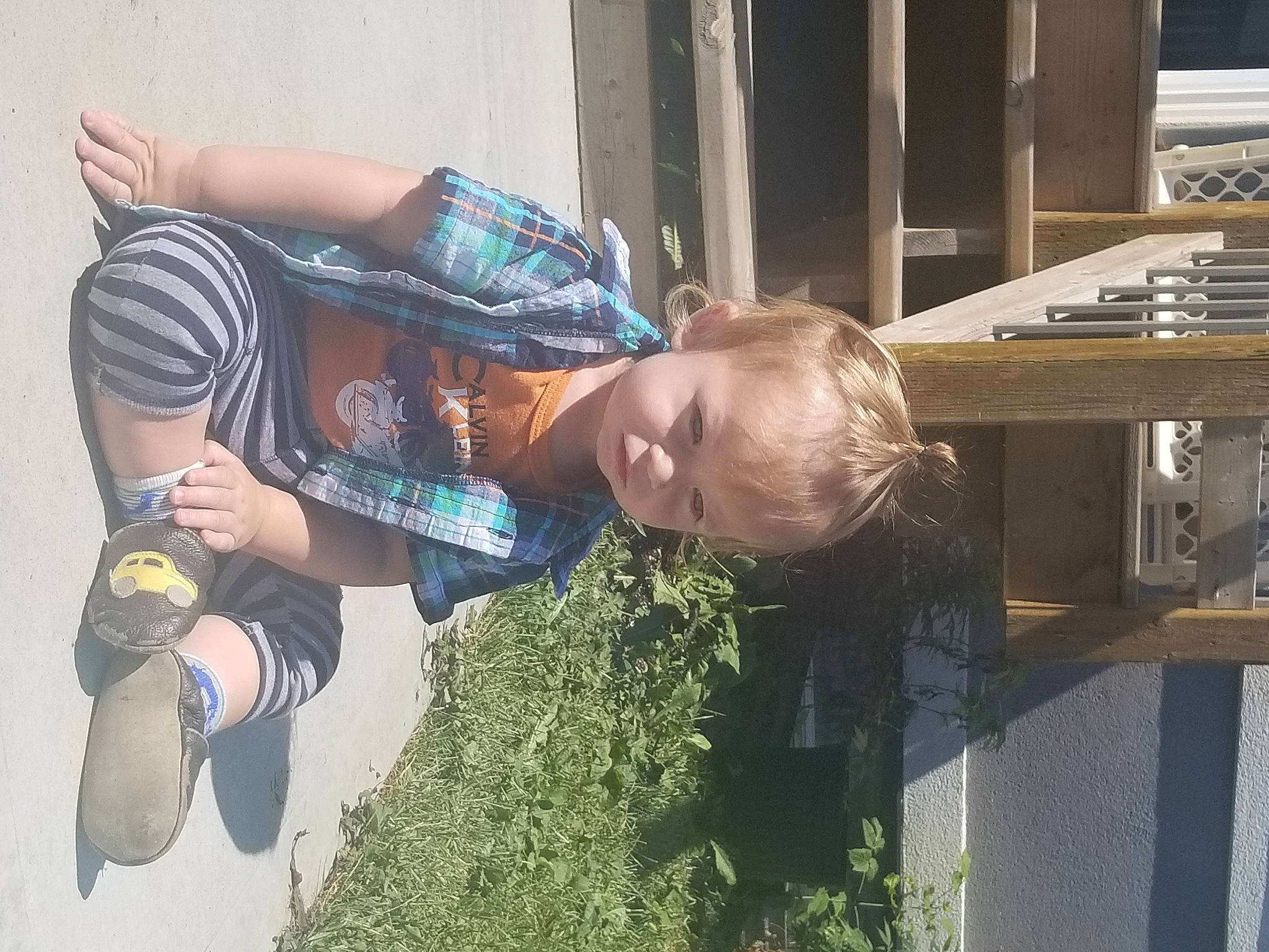 Noa is registered to the contest to win money with this photo: child, cool, elbow, eyewear, finger, fun, grass, happy, human_leg, leisure, person, plant, recreation, sitting, soil, t_shirt, toddler, tree