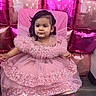 balloons, celebration, chair, child, cute, decor, dress, face, female_child, flooring, footwear, hair, indoor, party, pink_dress, portrait, seated, shiny, sparkle, toddler