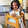 Laylah-Marie joined the competition — help win amazing prizes! carpet, child, couch, cute, decor, face, hair, happy, high_chair, indoor, legs, living_room, painting, person, playful, smiling, table, toddler, white_clothing, wooden_furniture
