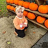 baby, child, pumpkins, pumpkin_patch, outdoor, autumn, fall, headband, bow, striped_shirt, orange, black_pants, kneeling, sidewalk, wooden_shelf, farmstand, portrait, blue_eyes, face, seasonal