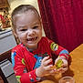 child, toddler, smiling, pajamas, toy, slime, table, kitchen, chair, curtain, red_curtain, wooden_furniture, happy, indoor, play, hands, face, person, home, cute