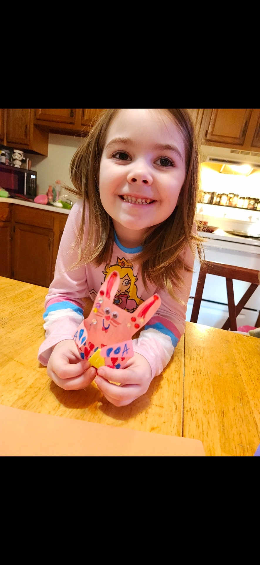 Addy is registered to the contest to win money with this photo: child, girl, smiling, craft, bunny, handmade, colorful, table, kitchen, wooden_table, long_hair, indoors, happy, person, art, toy, face, sitting, playful, home
