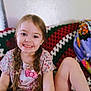 Addy is registered to the contest to win money with this photo: child, girl, smiling, braids, hello_kitty, shirt, couch, blanket, crocheted_blanket, indoor, happy, portrait, casual_clothing, cute, home, seated, young_child, playful, colorful, relaxed