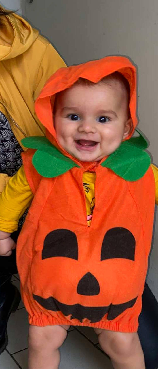 Ezio participe au concours pour gagner de l'argent avec cette photo : baby, cheek, chin, eye, face, happy, head, headgear, human_body, iris, joy, mouth, nose, orange, organ, outerwear, person, red, skin, sleeve