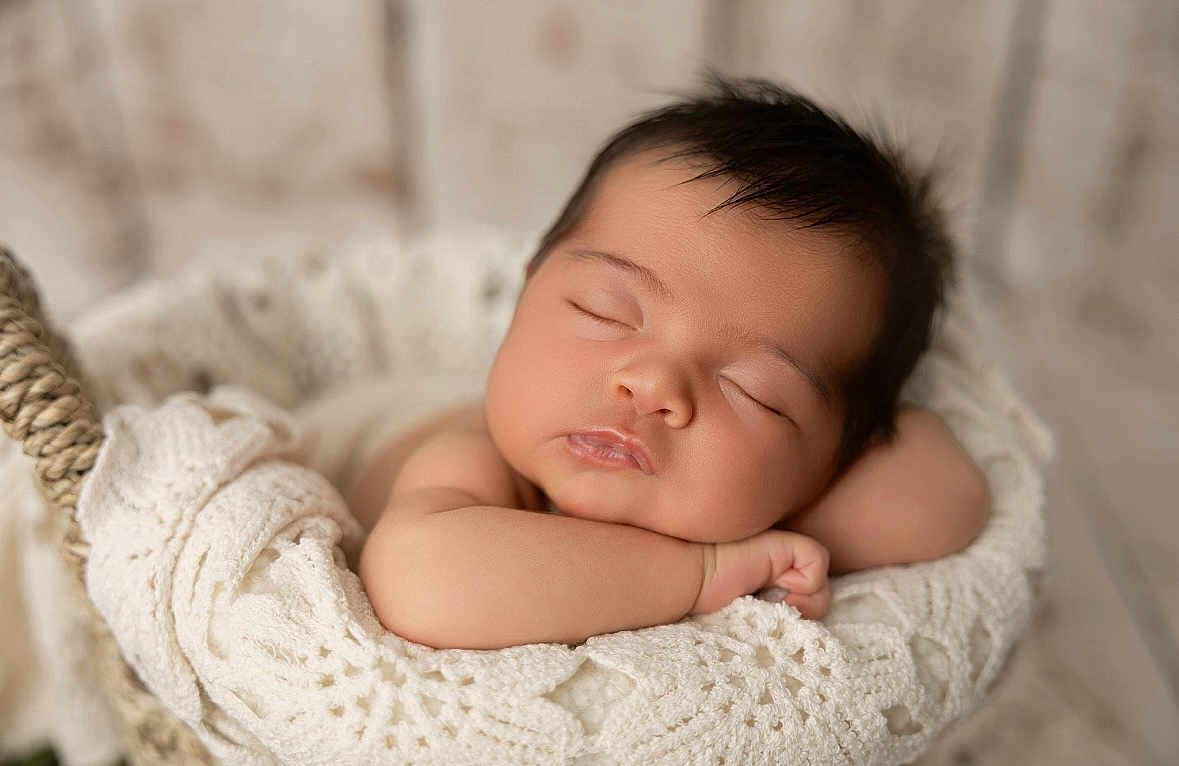 Nour a rejoint le concours — aidez-le/la à gagner de superbes lots ! baby, sleeping, newborn, basket, blanket, knitted, cozy, soft_lighting, peaceful, infant, cute, portrait, resting, arms_folded, indoors, closeup, soft_focus, child, adorable, warm
