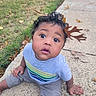toddler, child, curly_hair, autumn_leaves, outdoor, grass, sidewalk, gray_shirt, colorful_stripes, sitting, cute, wide_eyes, nature, fall, leaf_crown, concrete, casual_clothing, curious_expression, young_child, daylight