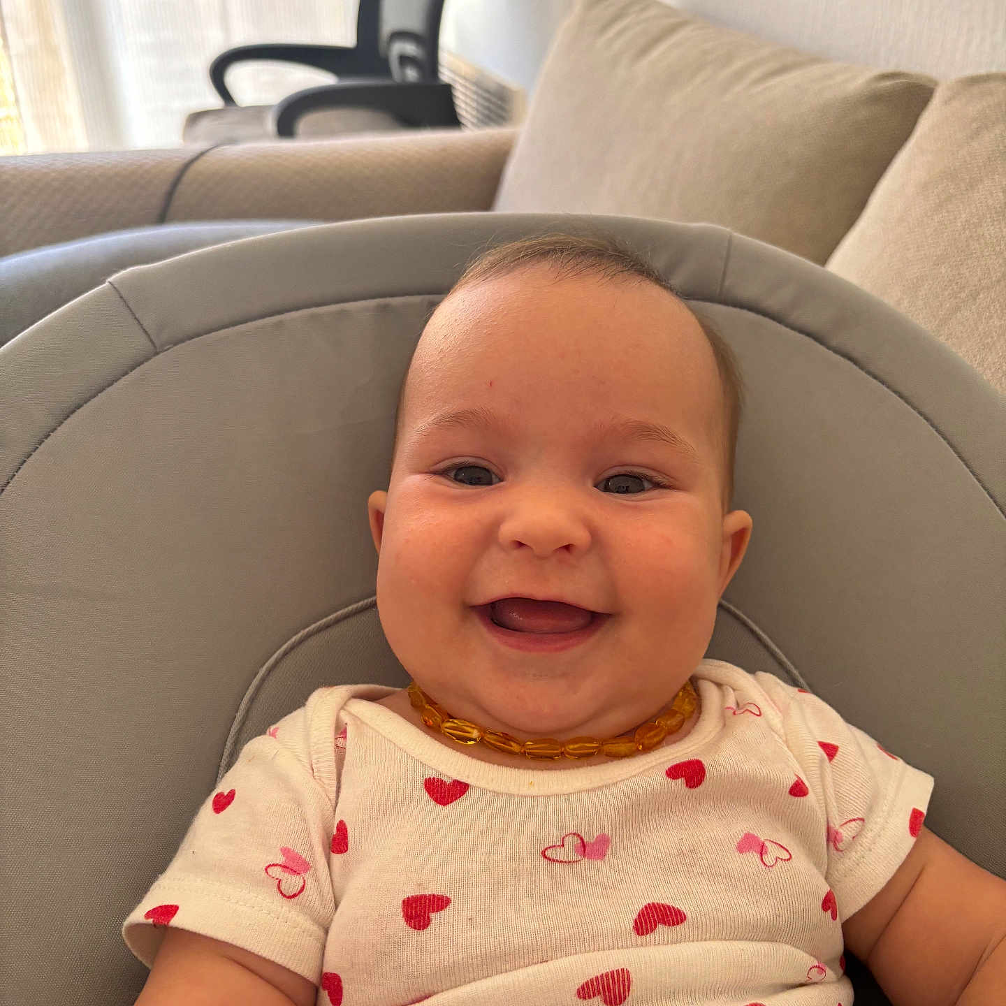 Nélya a rejoint le concours — aidez-le/la à gagner de superbes lots ! amber, baby, casual, chair, child, comfort, cushion, cute, happy, heart_pattern, indoor, infant, living_room, necklace, onesie, person, portrait, seat, smiling, sofa