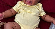 Niari joined the competition — help win amazing prizes! baby, infant, smiling, yellow_onesie, red_couch, milk_bottle, teething_toy, happy, child, sitting, cute, chubby_arms, chubby_legs, indoors, portrait, playful, young_child, furniture, cozy, person