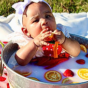 Auvree joined the competition — help win amazing prizes! baby, curious_expression, cute, decorative_bow, face, fruit, grass, hand, headband, infant, metal_tub, milk_bath, orange_slices, outdoor, picnic_blanket, red_clothing, skin, strawberries, summer, sunlight