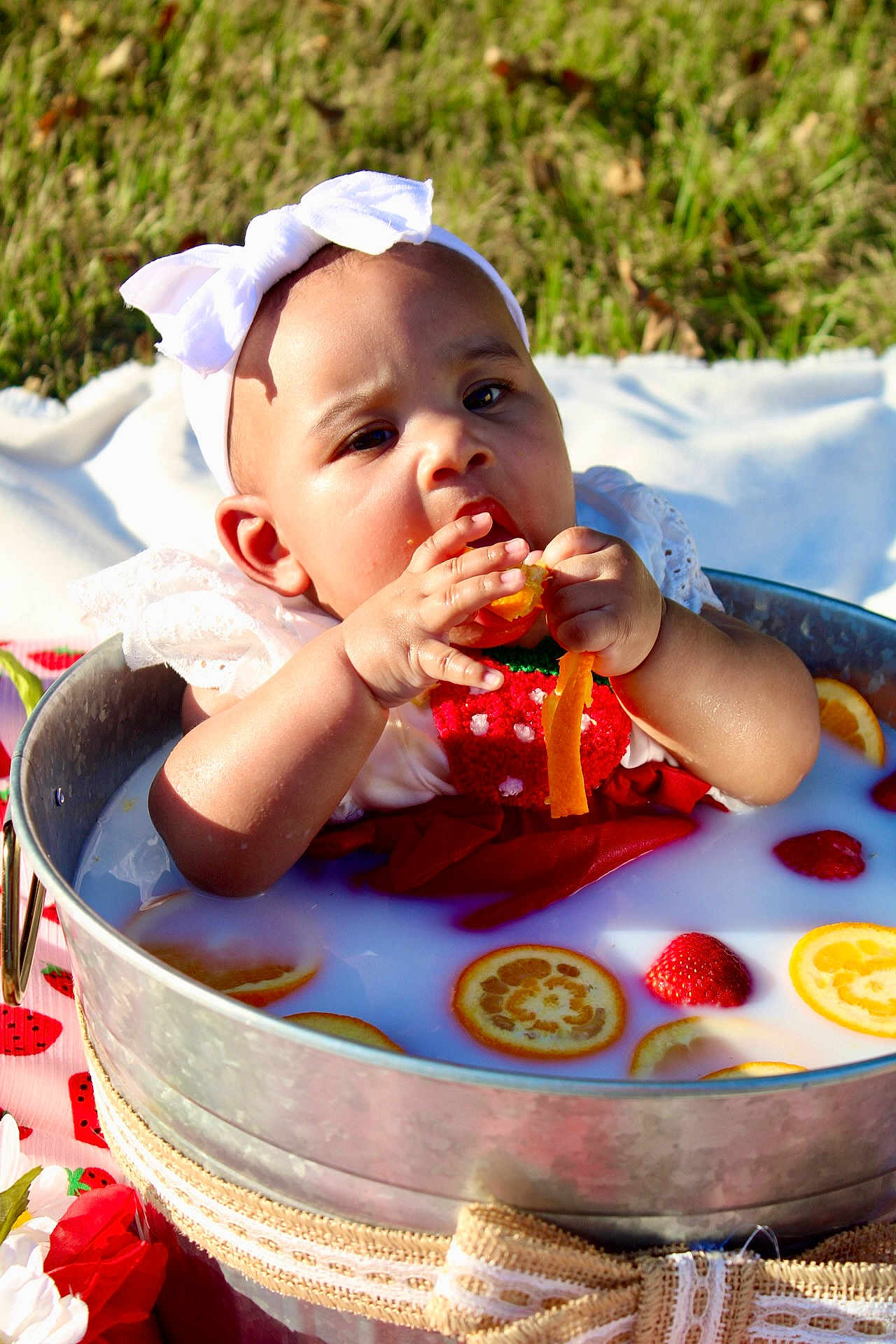 Auvree joined the competition — help win amazing prizes! baby, curious_expression, cute, decorative_bow, face, fruit, grass, hand, headband, infant, metal_tub, milk_bath, orange_slices, outdoor, picnic_blanket, red_clothing, skin, strawberries, summer, sunlight