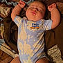 arms_up, baby, bed, blanket, child, cozy, cute, head, indoor, infant, legs, onesie, patterned_clothing, peaceful, person, resting, skin, sleeping, soft_lighting, toddler