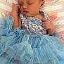 Arabella is registered to the contest to win money with this photo: baby, sleeping, headband, blue_dress, ruffles, pillow, floral_pattern, infant, cute, peaceful, soft, indoors, child, hand, foot, clothing, portrait, resting, toddler, face