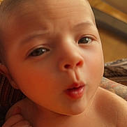 Arabella is registered to the contest to win money with this photo: baby, closeup, face, skin, head, eyes, mouth, hand, fist, expression, newborn, infant, child, portrait, human, cute, soft, warm, blanket, indoors