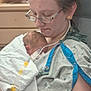 mother, newborn, baby, hospital, medical, blanket, woman, glasses, bedroom_furniture, medical_tube, patient_gown, care, love, indoor, person, healthcare, tenderness, holding, resting, closeup
