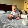 Jasper joined the competition — help win amazing prizes! baby, infant, bed, white_shirt, diaper, plush_toy, indoor, cozy, curious, child, person, furniture, blanket, head, smiling, seated, room, soft_light, happy, cute