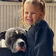 Shellya a rejoint le concours — aidez-le/la à gagner de superbes lots ! child, girl, dog, pigtails, smile, indoor, portrait, pet, animal, cozy, radiator, clothing, black_sweater, curly_hair, blonde_hair, friendship, cute, calm, closeup, human_animal_bond