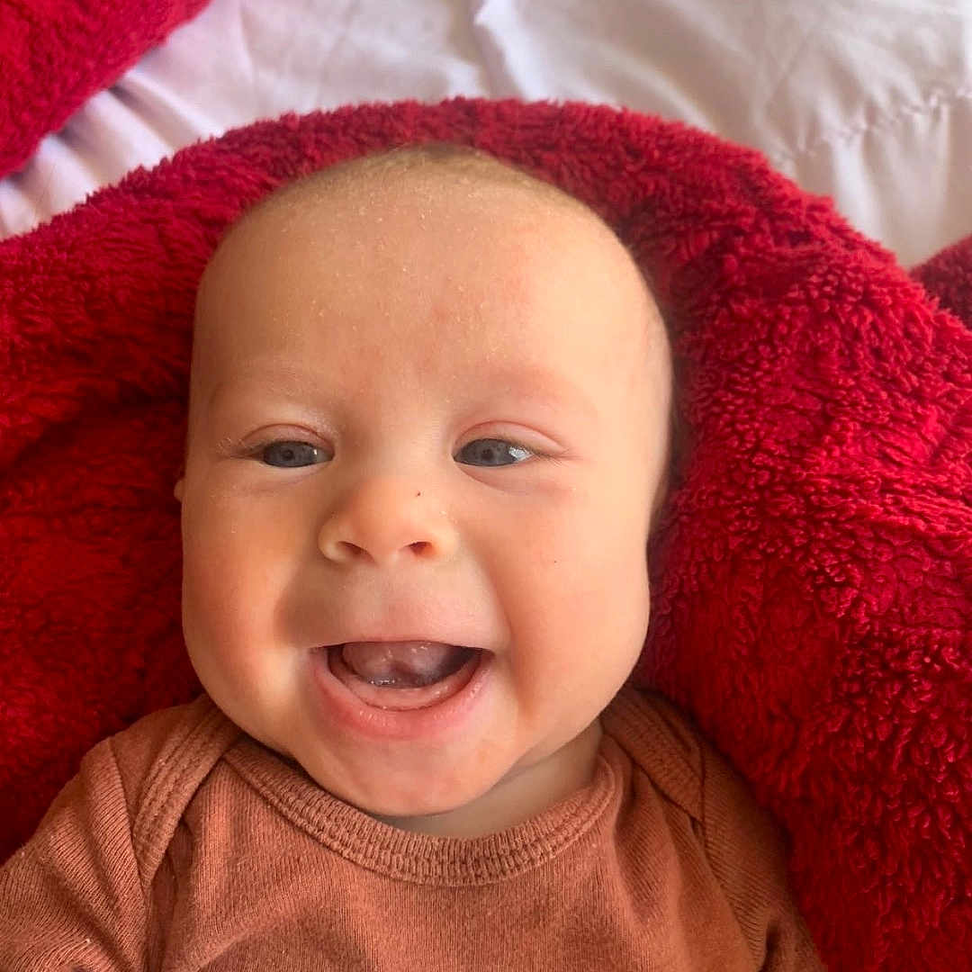 Benny joined the competition — help win amazing prizes! baby, babylaughing, blanket, clothing, cushion, face, happy, head, homedecor, hood, laughing, newborn, person, photography, portrait, quilt, smile, towel