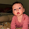baby, infant, child, pink_clothing, bed, blanket, toy, indoor, curious, blue_eyes, crawling, hands, face, head, young_child, portrait, cute, skin, person, warm_lighting