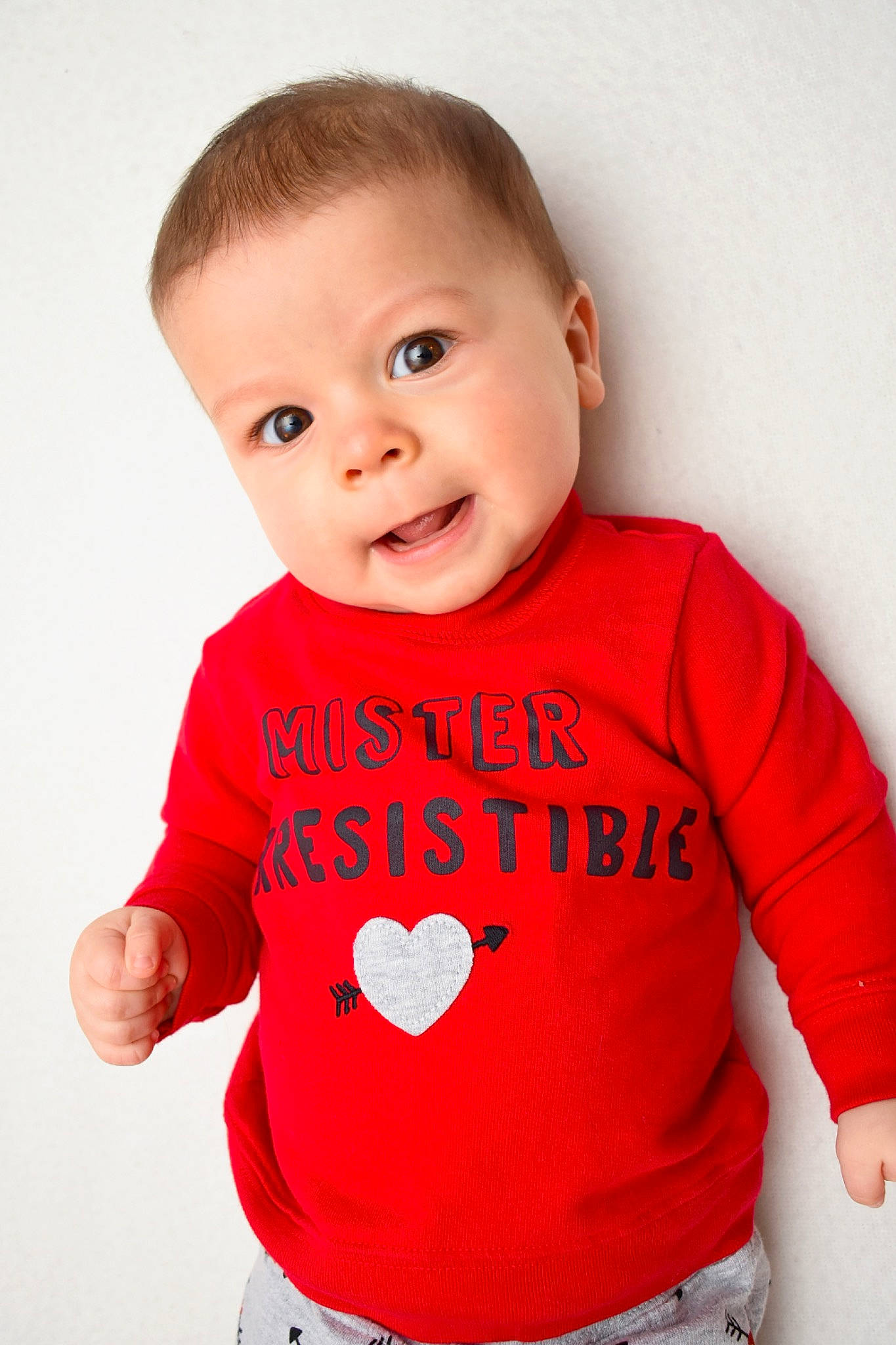 Cody is registered to the contest to win money with this photo: arm, baby, baby_toddler_clothing, child, clothing, electric_blue, facial_expression, finger, gesture, hair, happy, human_body, joint, neck, pattern, person, shoulder, sleeve, smile, t_shirt